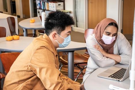 Peer consultant Raneem Rizvi, right, works with Shanlong Yu, a fifth-year Mechanical Engineering student from China, on a paper he is writing on Oct. 25, 2021 in the Naugle Comm Lab.