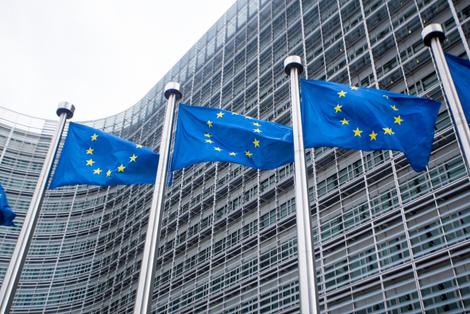 EU flags flying in front of building.